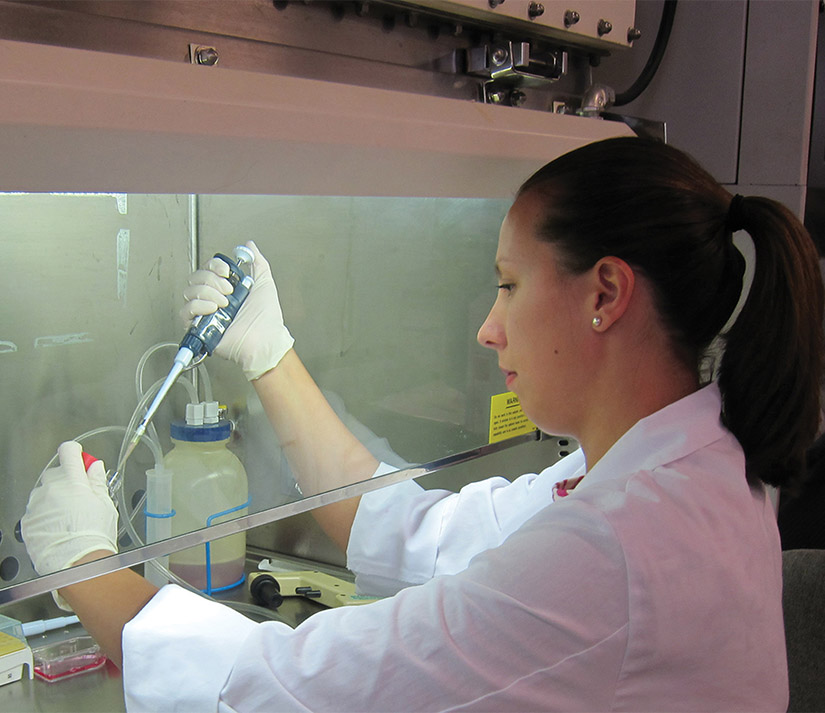 Photo, scientist working with dropper behind glass